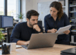Dos profesionales de soporte IT coordinan la recuperación cuando se cae el sistema de tu empresa.